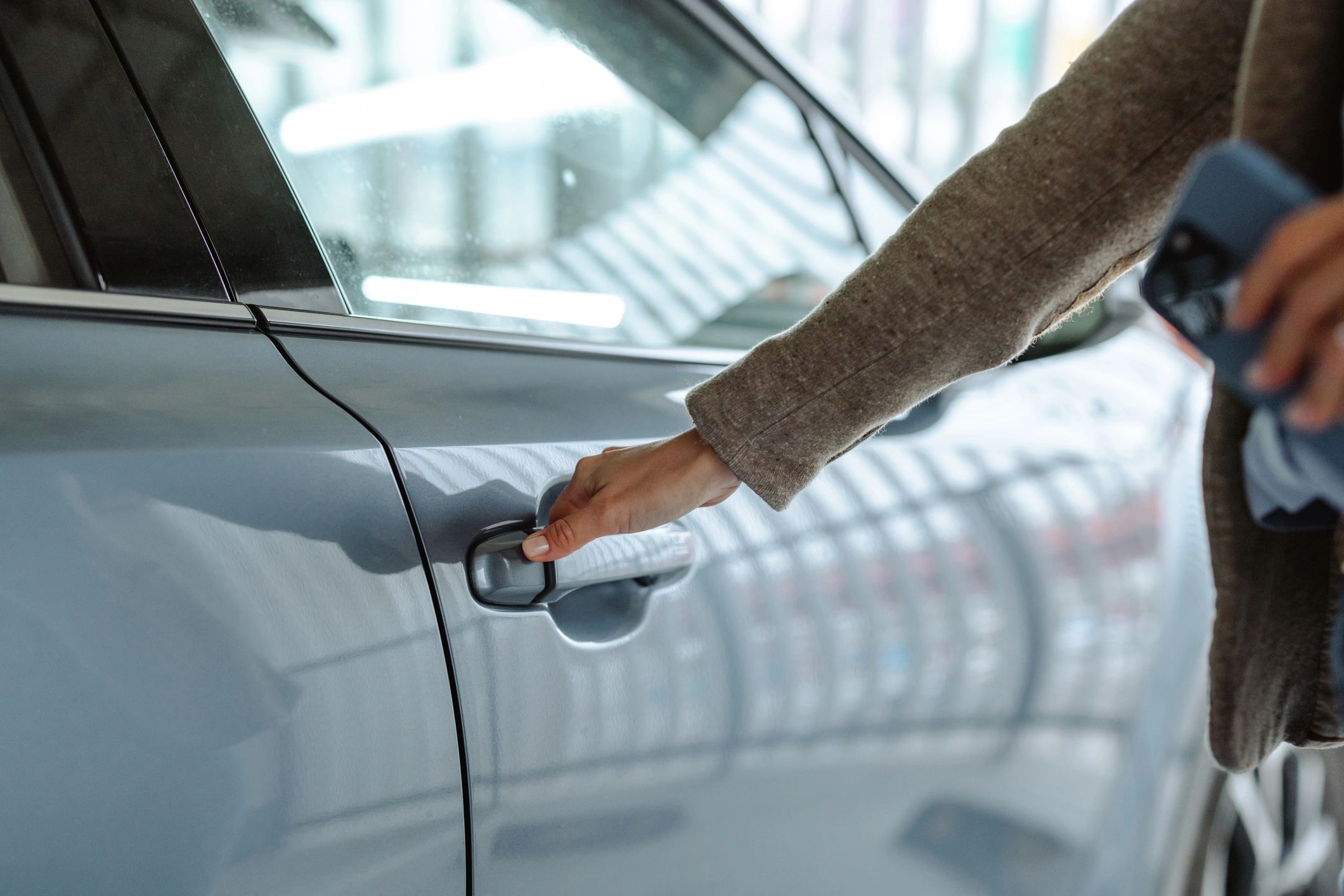 Person unlocking a parked car close-up